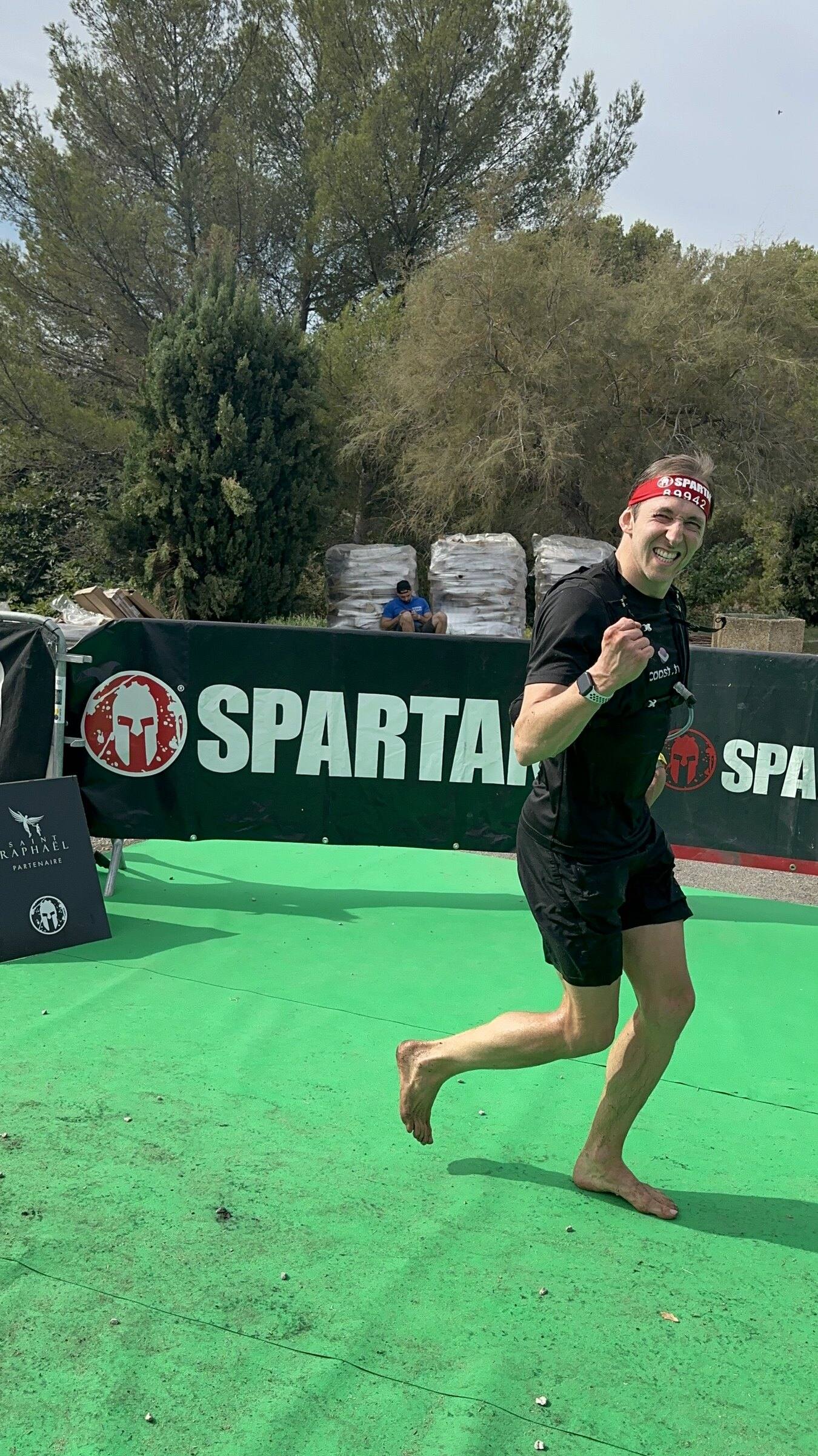 Antoine franchit la ligne d’arrivée pieds nus sur le tapis vert de la Spartan Race